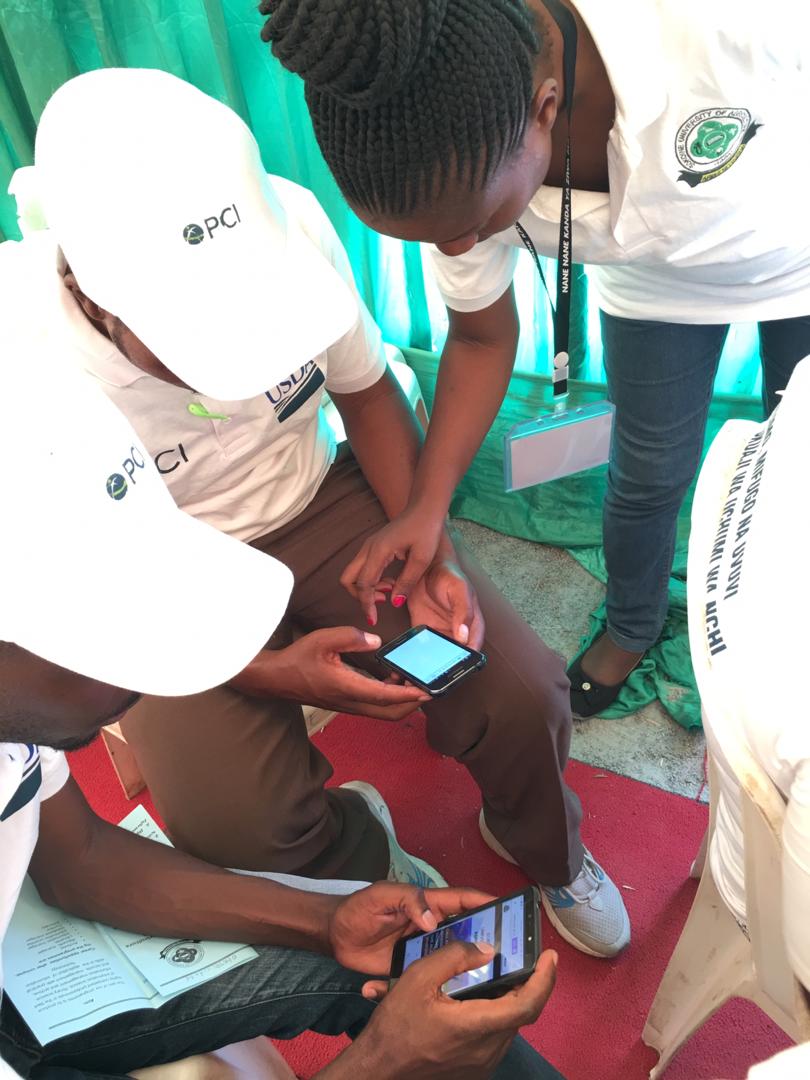 Ms Anajoyce showing farmers how to use phones to access information resources